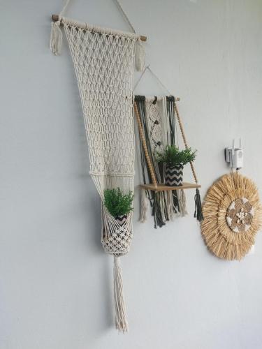 a white wall with two hanging plants on it at Mare Mia in Loutraki