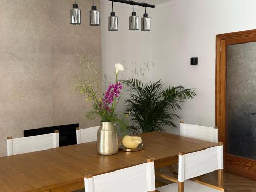 a dining room table with a vase of flowers on it at Can Vilàs in Muro