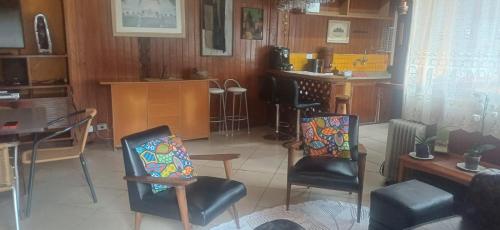 a living room with two chairs and a table at Pousada Toca das Bromelias in Campos do Jordão