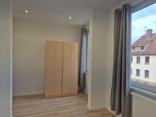 a room with a cabinet and a window at TuaCasa - Premium Gästehaus mit 5 Zimmern in Hessisch Oldendorf