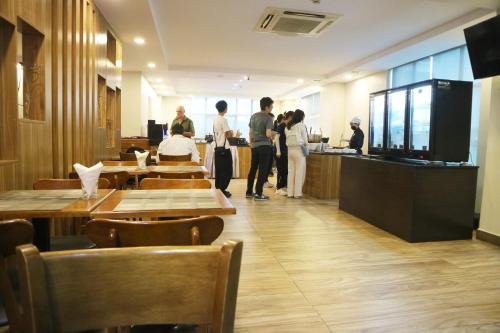 a group of people standing at a counter in a restaurant at HM Grand Central Hotel in Phnom Penh