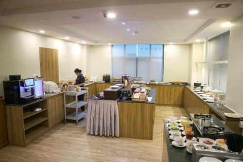 a kitchen with a person preparing food in a restaurant at HM Grand Central Hotel in Phnom Penh