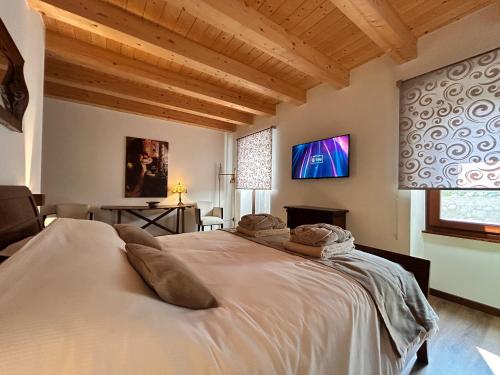 a bedroom with a large bed with a tv on the wall at Relais Villa Alma in Castion Veronese