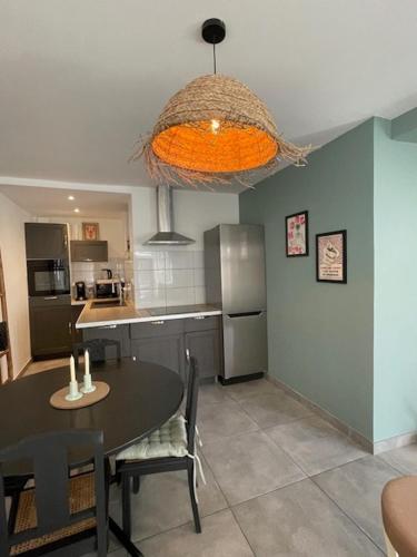 une cuisine avec une table et une salle à manger dans l'établissement La Maison du cadre, à Bergues