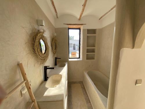 a bathroom with a sink and a tub and a toilet at Palais Bleu Nomade Essaouira in Aït Imouni
