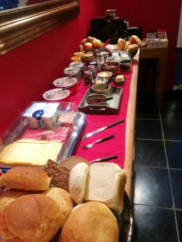 a long buffet of bread and pastries on a table at B&B De Gastfabriek in Tielt