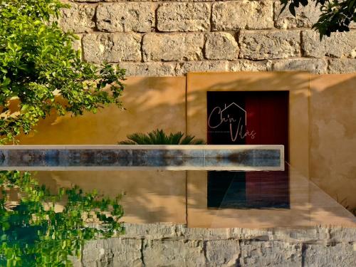 a stone wall with a bench in front of a building at Can Vilàs in Muro