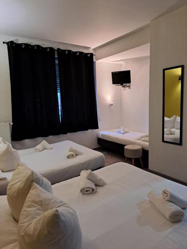 une chambre d'hôtel avec deux lits et une télévision à écran plat dans l'établissement LE PATIO, à Millau