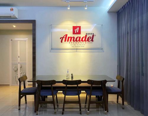 a table with chairs and a sign on a wall at Amadel Residence 爱媄德民宿 16 in Melaka