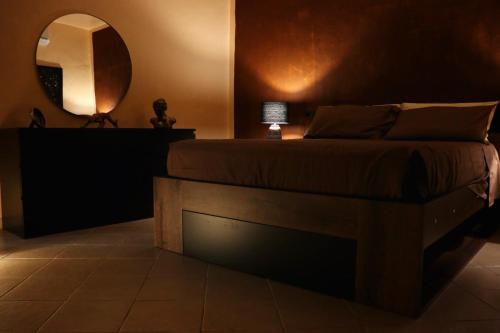 a bedroom with a bed and a mirror at Peaceful Hub Saturnia in Manciano