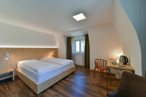 a bedroom with a bed and a table and a chair at Hotel Maloja Kulm in Maloja