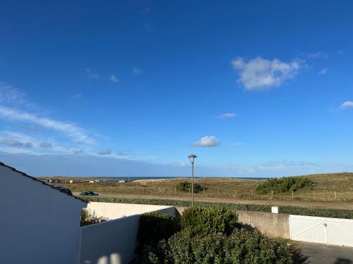 - une vue sur un champ avec un ciel bleu dans l'établissement Villa Dunes1 Bretignolles sur Mer, à Bretignolles-sur-Mer