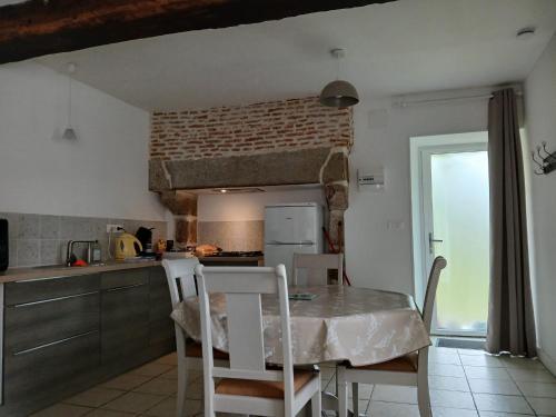 une cuisine avec une table et des chaises dans une pièce dans l'établissement Gîte Blonimael, à Vendrennes