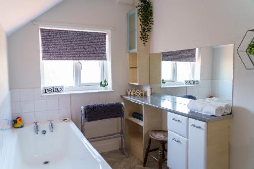 a bathroom with a tub and a sink and a bath tub at George Street Beverley in Beverley