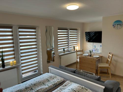a living room with a couch and a tv in it at Ferienwohnung Ritthoff Perlebucht - mit Strandkorb am Meer und kostenloser Eintritt ins Schwimmbad in Büsum