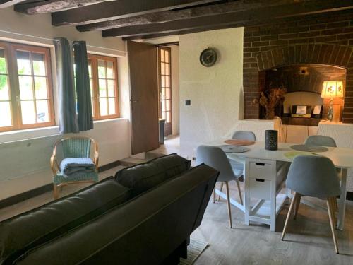 un salon avec un canapé et une table dans l'établissement Maison de campagne en Limousin, à Dury