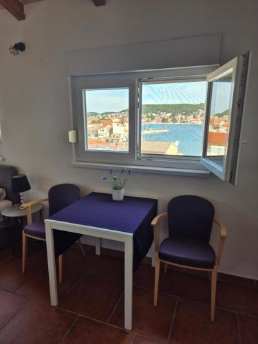 a table and two chairs and a table and two windows at Apartments Valentina Tisno in Tisno