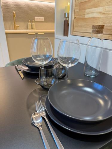 une table avec des assiettes et des verres à vin dessus dans l'établissement Calme & Élégance Studio de Charme proche Centre, à Aix-les-Bains