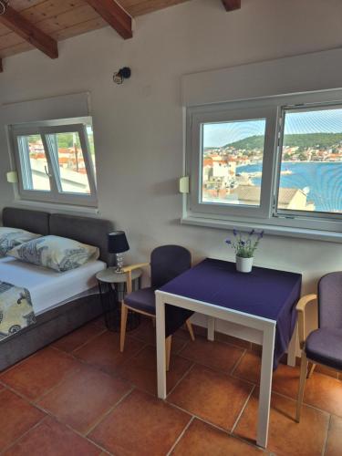 a room with a bed and a table and chairs at Apartments Valentina Tisno in Tisno