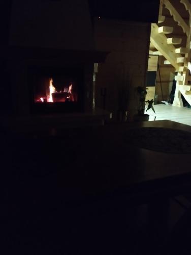 a fire in a fireplace in a dark room at Bajkowa Chatka in Bodzentyn
