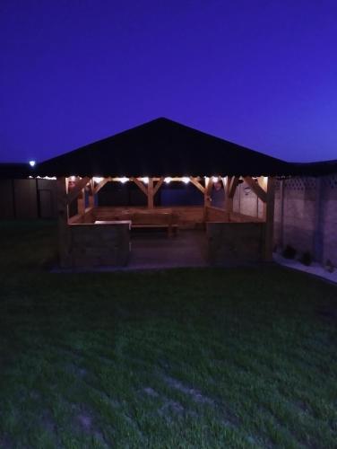 a gazebo with a picnic table at night at Bajkowa Chatka in Bodzentyn