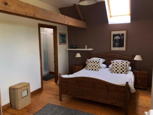 une chambre avec un lit avec des oreillers et une fenêtre dans l'établissement Les Moineaux, à Val Couesnon