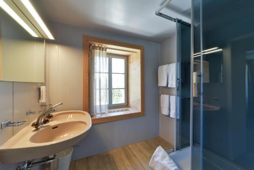 a bathroom with a sink and a glass shower at Hotel Maloja Kulm in Maloja