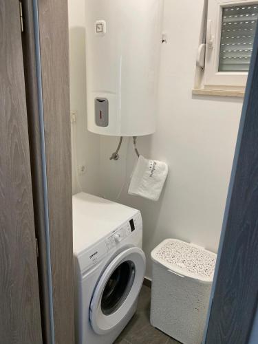a small bathroom with a washing machine and a toilet at Villa Fidelissima in Kaštela