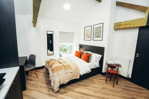 a bedroom with a large bed with orange pillows at Deluxe City Centre Studios in Derby