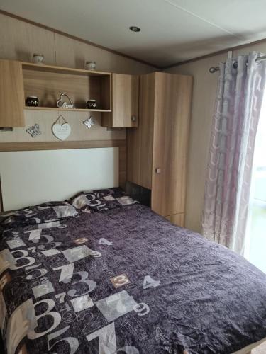 a bed with a quilt on it in a bedroom at Private Caravan to Hire - Marton Mere Haven Holiday Village in Blackpool
