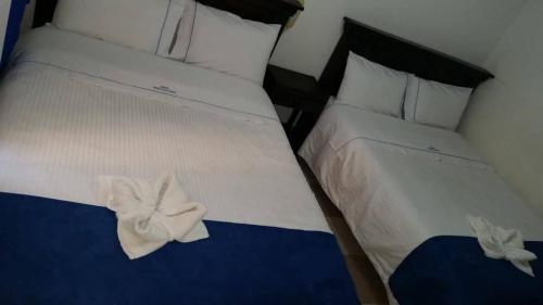 a bedroom with two beds with white towels on them at Nuevo Hotel Plaza Real in Sogamoso