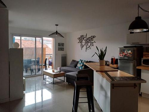 une cuisine et un salon avec un canapé dans l'établissement Appartement T2 CANNES LA BOCCA, à Cannes