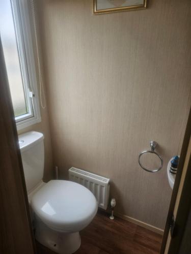 a bathroom with a white toilet and a window at Private Caravan to Hire - Marton Mere Haven Holiday Village in Blackpool