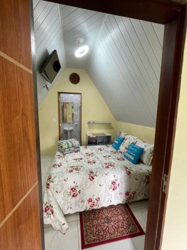 a bedroom with a large bed in a attic at Chalé das hortênsias in Bonito