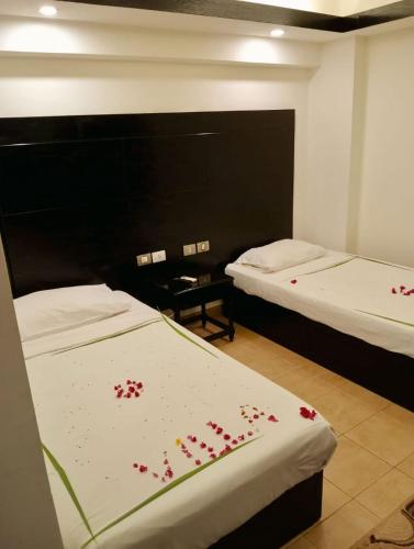 a room with two beds with red flowers on the sheets at Villa Silia in Sharm El Sheikh