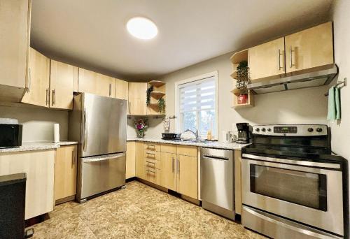 a kitchen with wooden cabinets and stainless steel appliances at Homestay At Major Mackenzie Drive-CENTRAL LOCATION-WALKING PLAZA in Richmond Hill