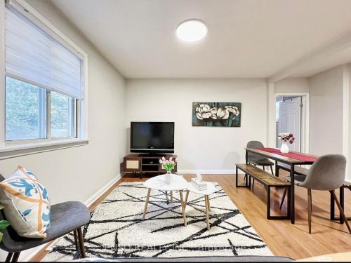 a living room with a table and chairs and a tv at Homestay At Major Mackenzie Drive-CENTRAL LOCATION-WALKING PLAZA in Richmond Hill