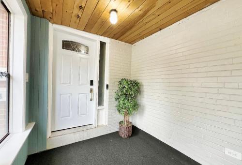 a porch with a door and a potted plant at Homestay At Major Mackenzie Drive-CENTRAL LOCATION-WALKING PLAZA in Richmond Hill