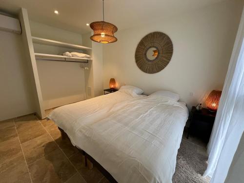 une chambre avec un lit blanc et un miroir dans l'établissement Le Cinglé du Ventoux, à Malaucène