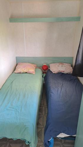 deux lits côte à côte dans une pièce dans l'établissement Le fief, à Le Tablier