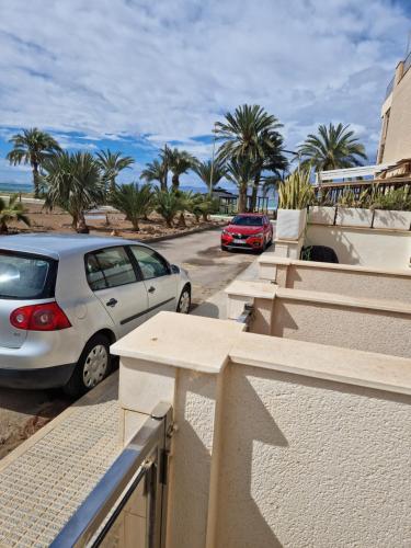 two cars parked in a parking lot with palm trees at Casa Krystyna La Azohia in Cartagena
