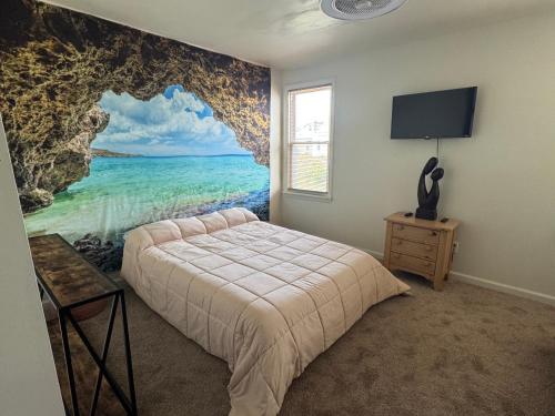 a bedroom with a painting of the ocean on the wall at Kennedy Village on Melrose Ave in Atlantic City