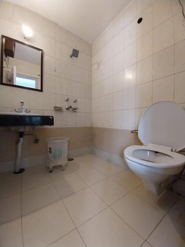 a bathroom with a toilet and a sink and a mirror at The Bunkk Inn Hotel & Restaurant - Mussoorie International in Mussoorie