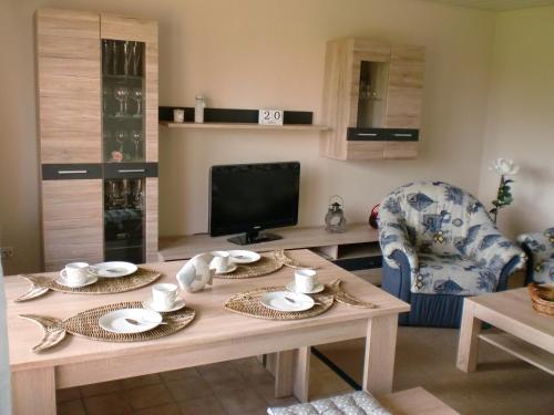 ein Wohnzimmer mit einem Holztisch und einem TV in der Unterkunft Ferienhaus Dorit & Rüdiger Fahl in Klocksdorf