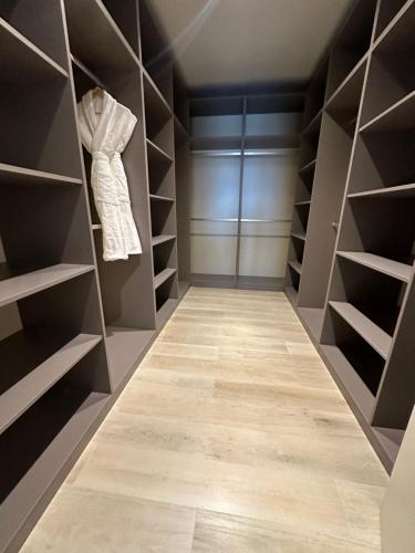 a walk in closet with gray walls and wooden shelves at Sea breeze Park Residens 2 in Nardaran