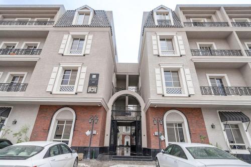 two cars parked in front of a building at Mabaat-Superior 2BR-Al Narjis 582 in Quai