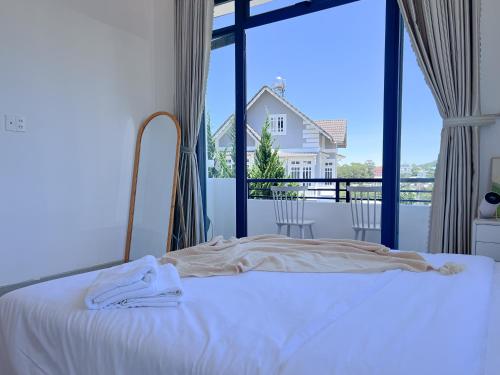 a bedroom with a bed and a large window at Lux Nest Villa Đà Lạt in Da Lat