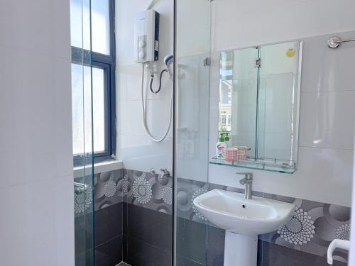 a bathroom with a sink and a glass shower at Lux Nest Villa Đà Lạt in Da Lat