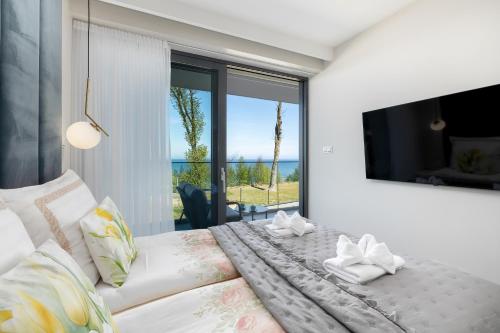 a bedroom with a white bed and a large window at Sea View Baltic Lux Hevenia in Rewal