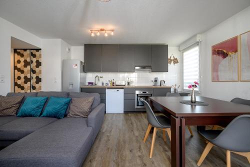 un salon avec un canapé et une table et une cuisine dans l'établissement L antre ensoleillee du Minotaure, Parking, à Toulouse